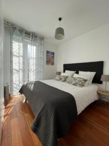 a bedroom with a large bed with a black blanket at Appartement 7 personnes - Disneyland Paris in Serris