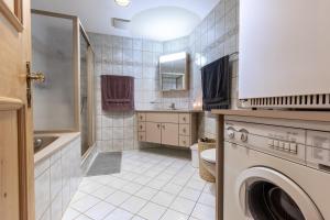 a bathroom with a washing machine and a sink at Chasa Vi in Scuol