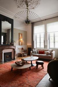 a living room with a couch and a fireplace at La Maison Mulatô, demeure privée d'hôtes, piscine & spa Libourne, Saint-Emilion in Libourne