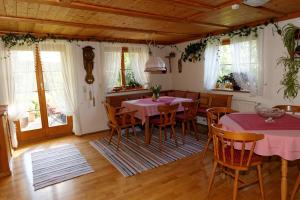 a dining room with two tables and chairs and windows at Gästehaus Möschel in Weiler-Simmerberg