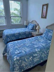 two beds in a room with blue sheets at Tropical Elegant Palm Beach 2 Bedroom 2 Bathroom Suite Valet Parking Included in Palm Beach