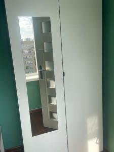 a door with a mirror in a room with a window at apartament Prokocim in Krakow
