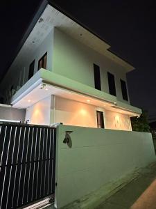 a white house with a gate in front of it at night at House40 - MRT Ratchadaphisek in Bangkok