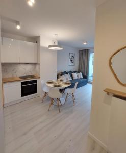 a kitchen and living room with a table and chairs at Harmony Pearl Apart in Rogowo