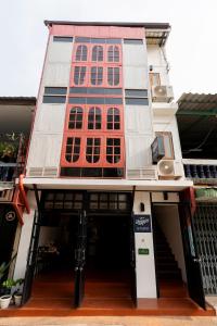 a building with a red and white building at Ubon Huan Kaew อุบลเฮือนแก้ว in Ban Na Khwai