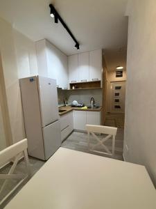 a kitchen with a refrigerator and two chairs in it at Max Apartments in Podgorica