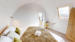 Un dormitorio con una cama con zapatos blancos. en Byrnside Lodge, en Latheron