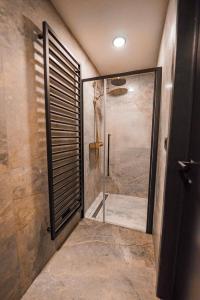 een badkamer met een douche en een glazen deur bij Hotel Mezza Notte in Ronse