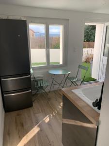 a kitchen with a refrigerator and a table with chairs at Studio Calme aux terrasses de Cassis in Cassis