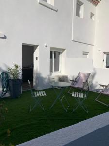 a patio with two chairs and a table on grass at Studio Calme aux terrasses de Cassis in Cassis