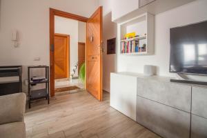 Olbia Oasis Apartment with Two Balconies! في أولبيا: غرفة معيشة مع تلفزيون بشاشة مسطحة وأريكة