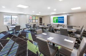a conference room with tables and chairs and a screen at Holiday Inn Express Hotel & Suites Birmingham - Inverness 280, an IHG Hotel in Birmingham