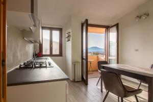 a kitchen with a stove top oven next to a table at Olbia Oasis Apartment with Two Balconies! in Olbia