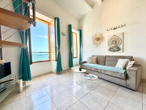 a living room with a couch and a large window at Le St Julien Terrasse vue mer exceptionnelle in Menton