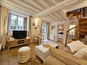 een woonkamer met een bank en een tv bij Le Moulin - Wifi - Mana Conciergerie in Culey-le-Patry