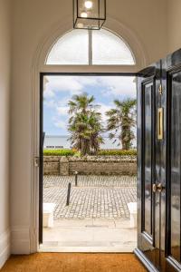 an open door to a patio with palm trees at FOX ON THE HOE in Plymouth