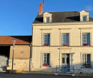 a large white building with windows on a street at Le clos Pascaline in Noyers-sur-Cher