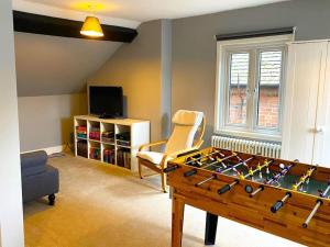 a living room with a table and a chair at The Old School House - Parking & Close to City in Salisbury
