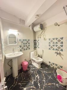 ein Bad mit einem Waschbecken und einem WC in der Unterkunft HOTEL PURNI DARJEELING in Darjeeling