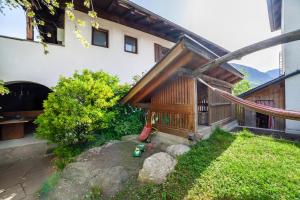 a backyard with a wooden building and a playground at Gasserhof Ferienwohnung Morgenduft in Caines