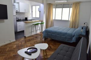 a kitchen and a living room with a bed and a table at Belgrano Cozy Suite in Buenos Aires