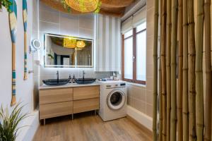 Un baño con lavadora y lavadora y secadora. en CathyVoyages - Ciel étoilé - Bord de Mer - Parking gratuit - Vidéoprojecteur - Lit rond - La Paillote Strasbourgeoise, en Estrasburgo