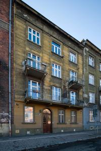 um antigo edifício de tijolos com varandas numa rua em Zjawiskowy apartament obok Dworca Głównego z Netflix i AC em Cracóvia