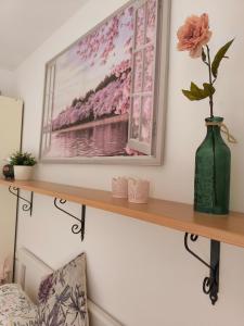 een plank met een foto en een vaas erop bij Apartment Dragonfly - garden and pool in Manerba del Garda