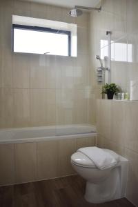 a bathroom with a toilet and a bath tub at Sleek 2 bed with balcony in Brentwood in Brentwood