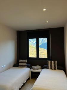 2 Betten in einem Zimmer mit Fenster in der Unterkunft Mirador del Verd in San Lorenzo de Morunys