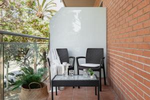 2 Stühle und ein Tisch auf der Terrasse in der Unterkunft Apartments Sata Olimpic Village Area in Barcelona