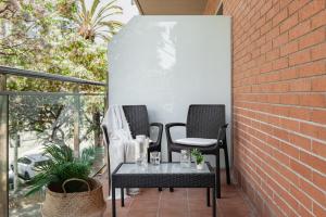 Duas cadeiras e uma mesa num pátio em Apartments Sata Olimpic Village Area em Barcelona