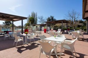 een groep tafels en stoelen op een patio bij SOWELL Family Cap d’Agde in Cap d'Agde