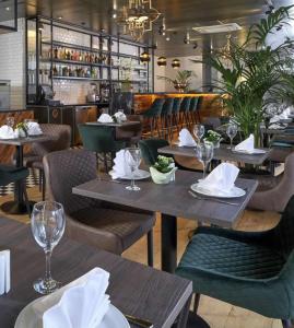 a restaurant with wooden tables and chairs and a bar at Battersea Bridge Ultra Central London One Bedroom Apartment 10 mins walk to Kings Road Chelsea in London
