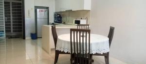 uma cozinha com uma mesa, 2 cadeiras e um frigorífico em The Elements @ Ampang em Kuala Lumpur