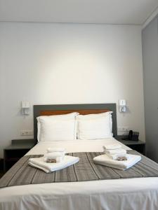 a large bed with two white towels on it at Aliança café & hostel in Angra do Heroísmo