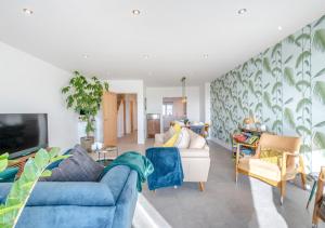 - un salon avec un canapé bleu et des chaises dans l'établissement Sandy Toes - Dartmouth, à Stoke Fleming