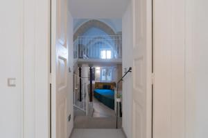 a hallway leading to a bedroom with a blue bed at Corte dei Condò Luxury Rooms in Lecce