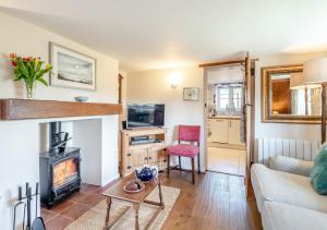 sala de estar con sofá y chimenea en White Rose Cottage, en Bodham