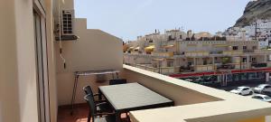a balcony with a bench and a view of a city at Paraíso con gran solarium privado en playa Mogán in Puerto de Mogán