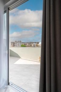 een glazen schuifdeur met uitzicht op een balkon bij Msida Central Suites in Msida