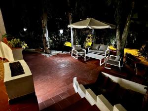 a patio with chairs and an umbrella at night at Villetta a 100mt dal mare in Santa Caterina di Nardò