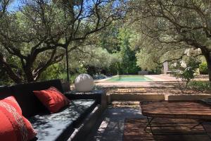 a bench with red pillows next to a pool at La Matina Family Haven with Olive Garden Oasis in Lauris