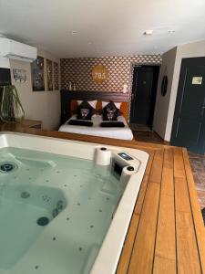 a large bath tub in a bedroom with a bed at SUITE 785 jacuzzi in Montauban