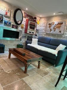 ein Wohnzimmer mit einem blauen Sofa und einem Couchtisch in der Unterkunft SUITE 785 jacuzzi in Montauban