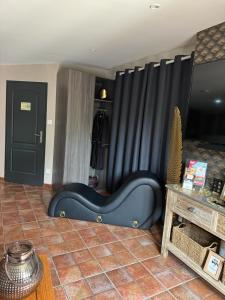 a blue couch in a room with a black curtain at SUITE 785 jacuzzi in Montauban