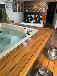 a bedroom with a large bath tub with a bed at SUITE 785 jacuzzi in Montauban