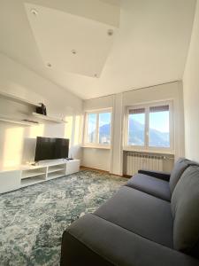 uma sala de estar com um sofá e uma televisão de ecrã plano em Le Case Di Ferdinando em Lecco