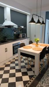 a kitchen with a table and chairs in a room at APARTAMENTOS FERNANDO III EL SANTO in Baeza