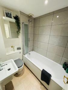 a bathroom with a tub and a toilet and a sink at County House City Centre with parking Sleeps 4 in York